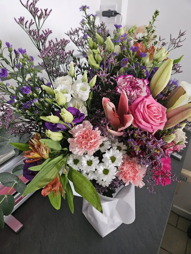 Bouquet de lys, roses et lisianthus dans les tons mauves