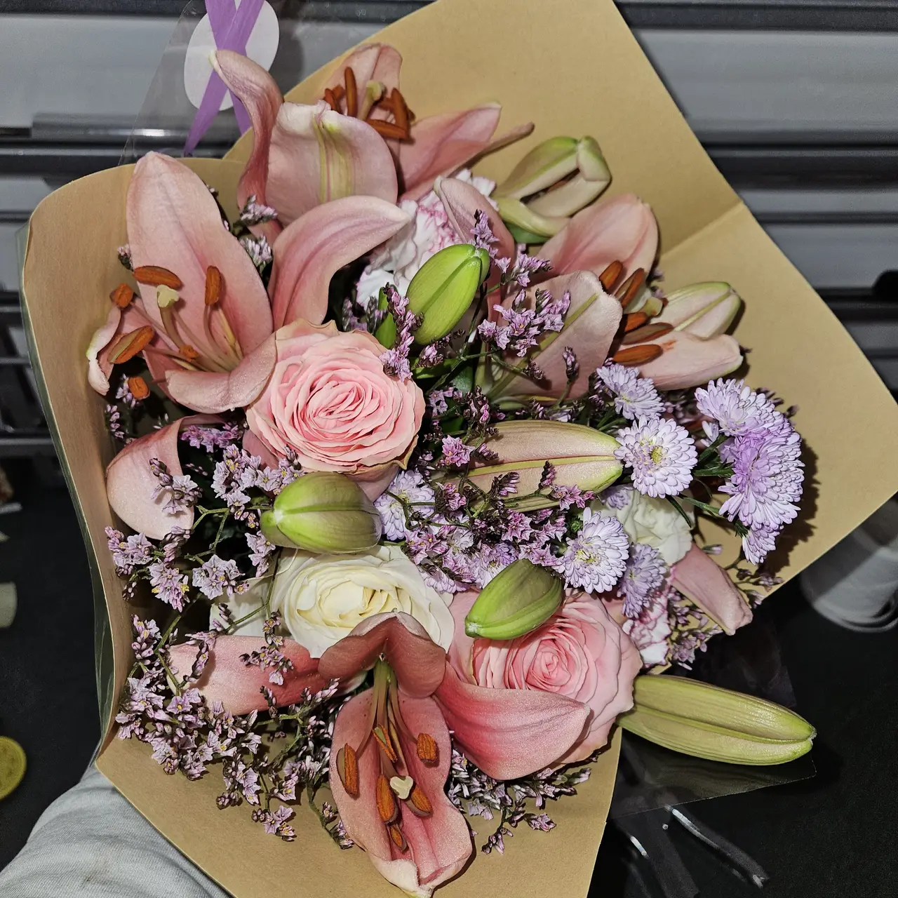Bouquet de lys roses, roses et fleurs mauves dans un papier kraft