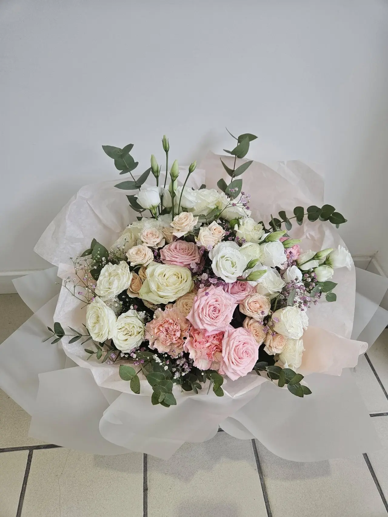 Bouquet de mariée pastel : roses blanches et roses, lisianthus, gypsophile et eucalyptus
