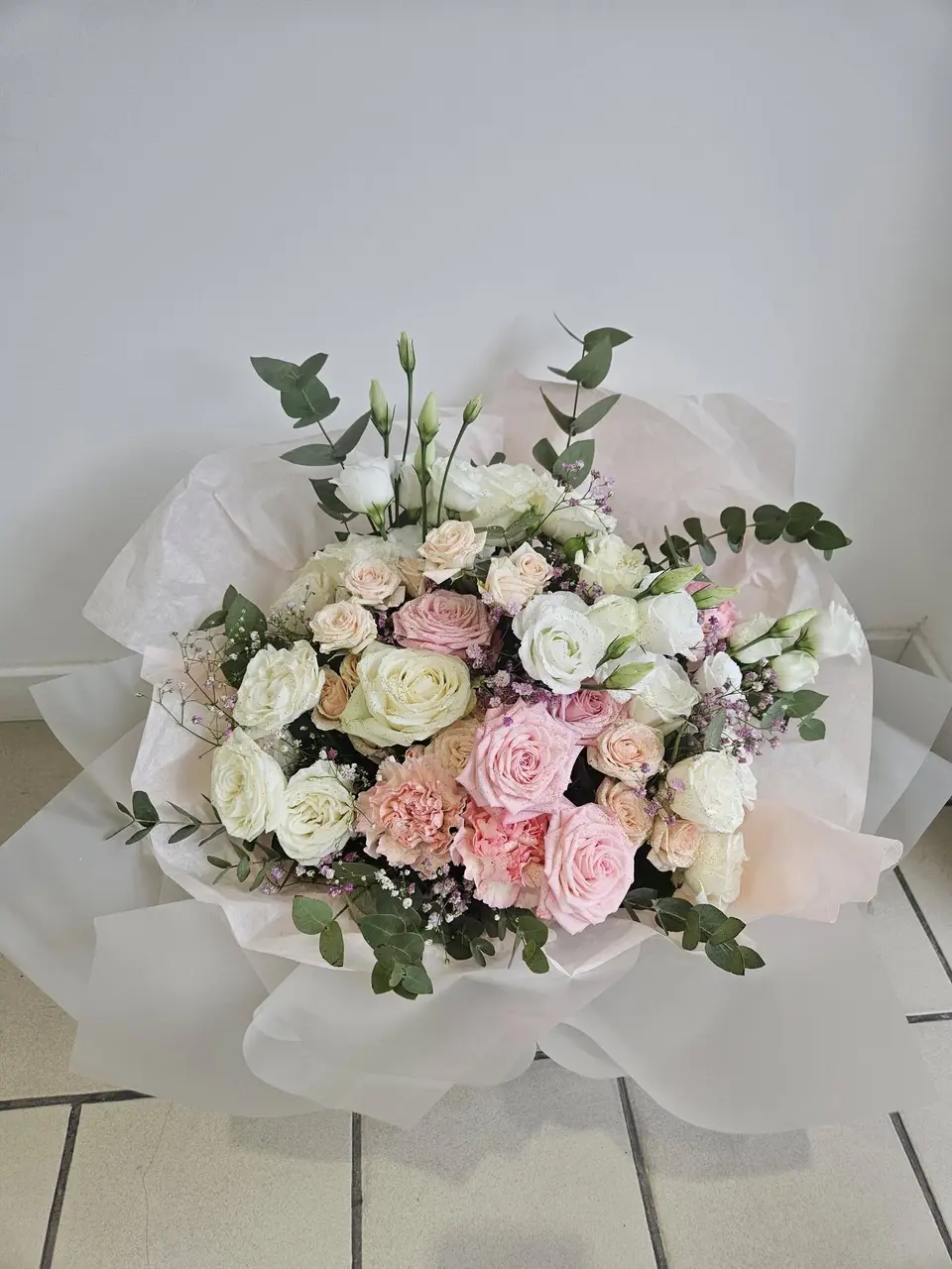 Bouquet de mariée pastel : roses blanches et roses, lisianthus, gypsophile et eucalyptus
