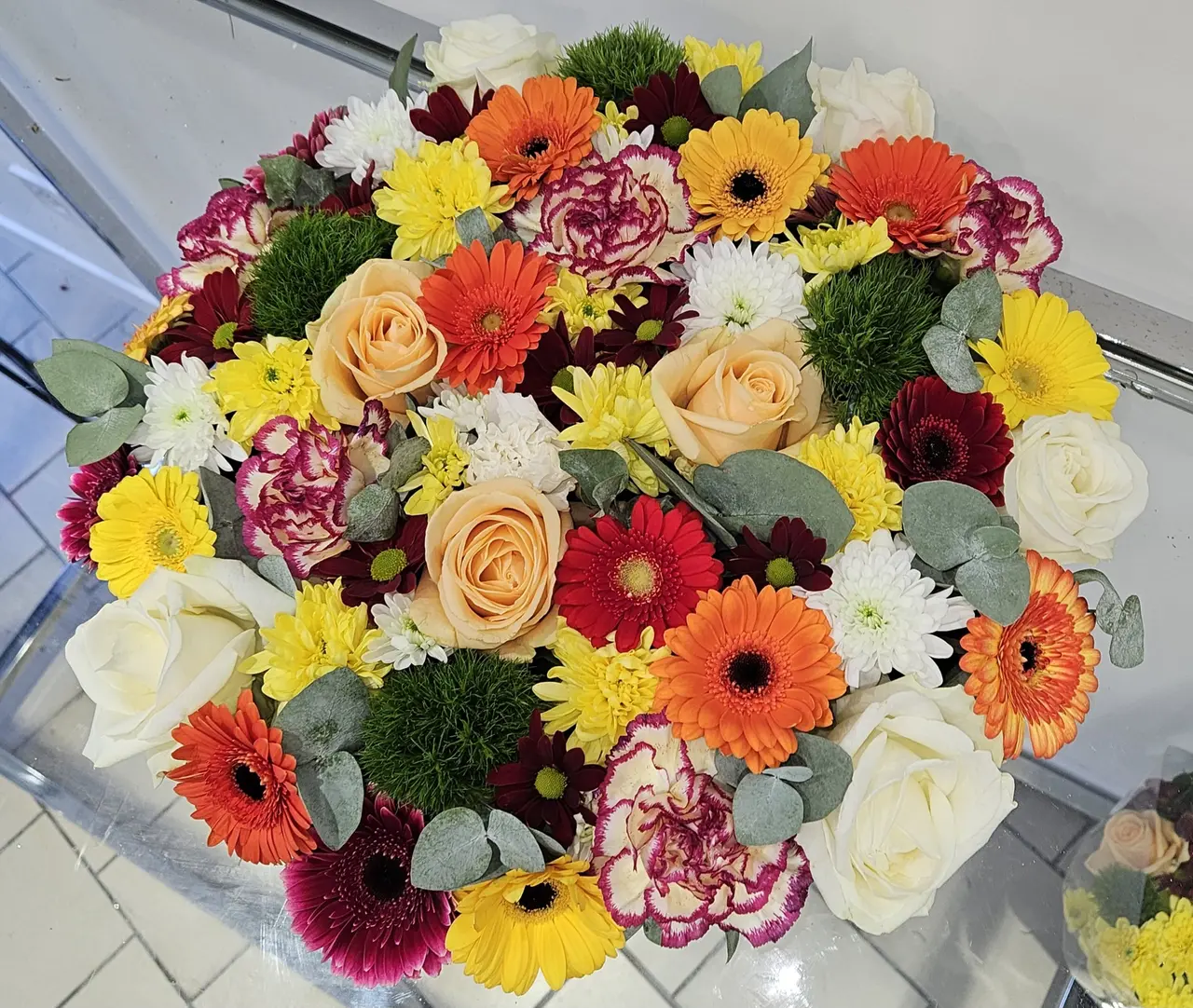 Bouquet multicolore de gerberas, roses et œillets vu de dessus