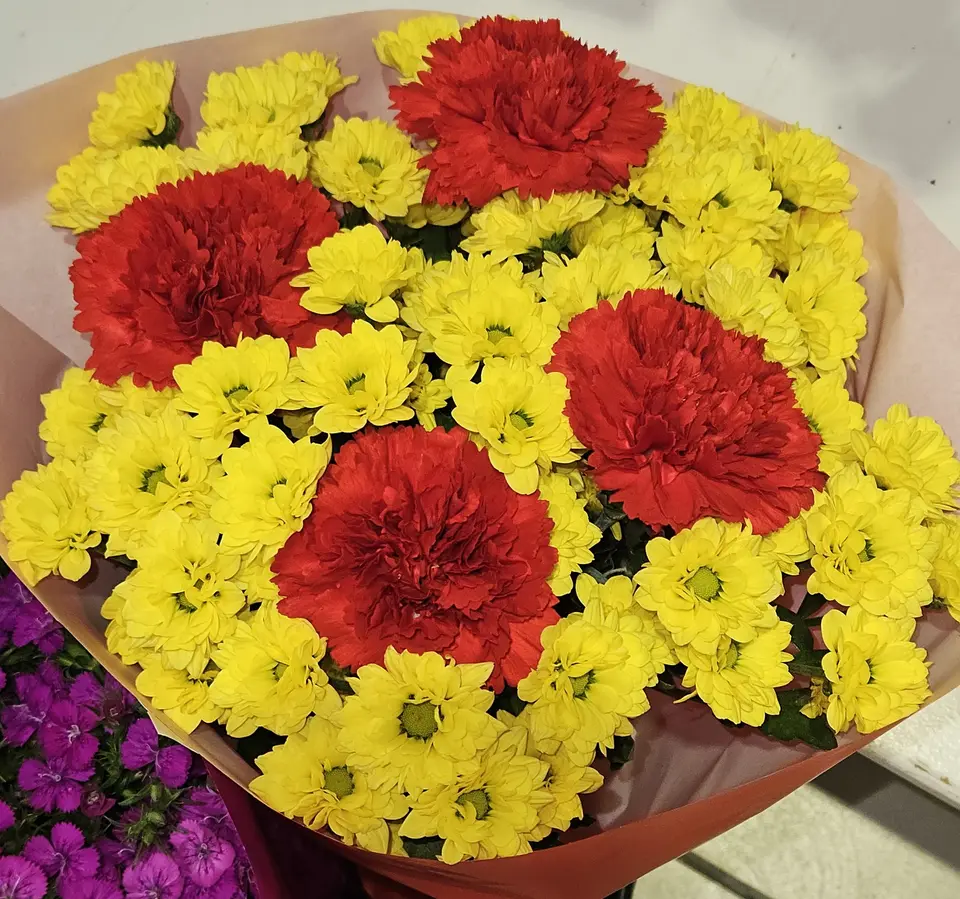 Bouquet d'œillets rouges et de chrysanthèmes jaunes
