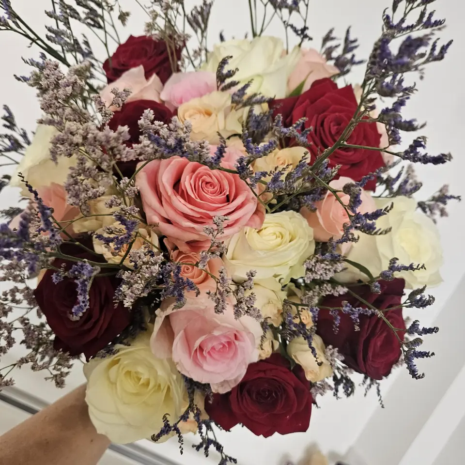 Bouquet de roses roses et bordeaux relevé de limonium