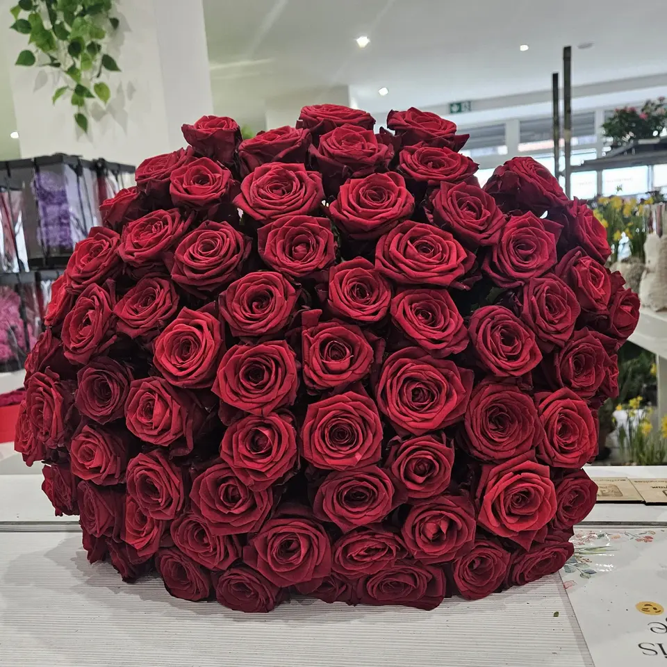 Grande brassée de roses rouges présentée en boutique