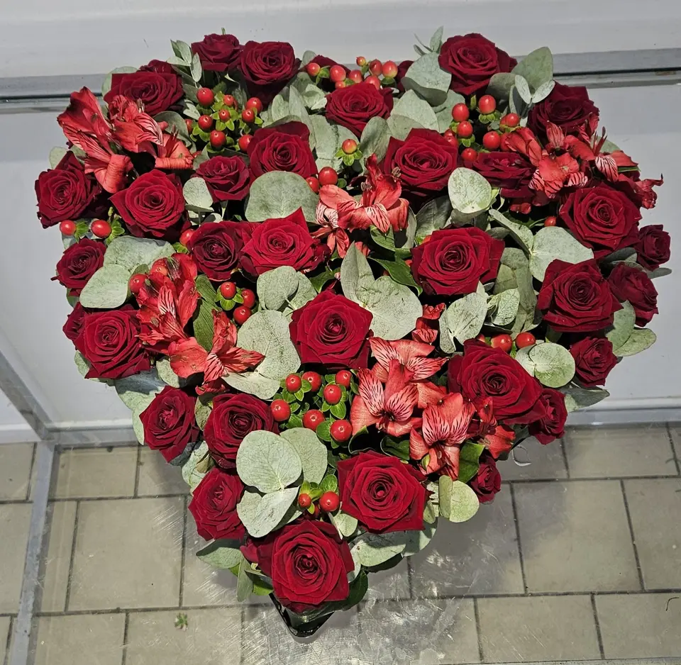 Cœur de deuil en roses rouges, alstroemerias, hypericum et eucalyptus