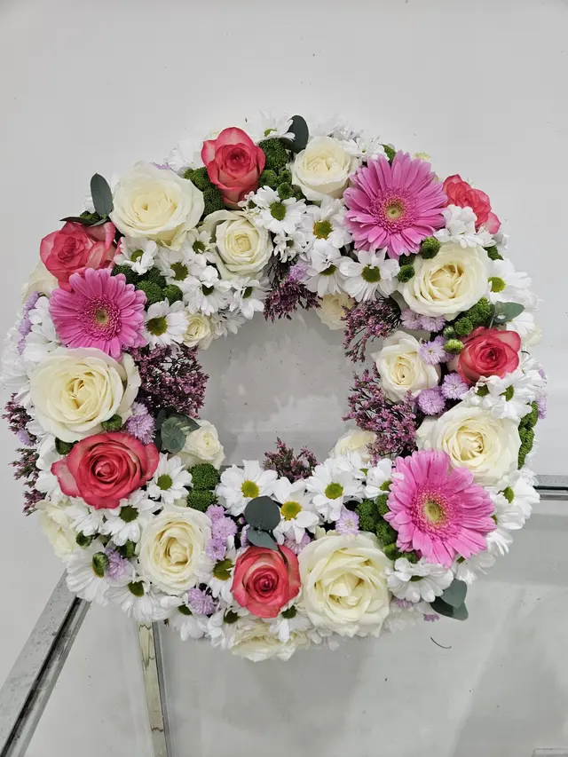 Couronne de deuil rose et blanche aux roses et gerberas