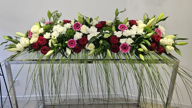 Dessus de cercueil rose et rouge avec lys