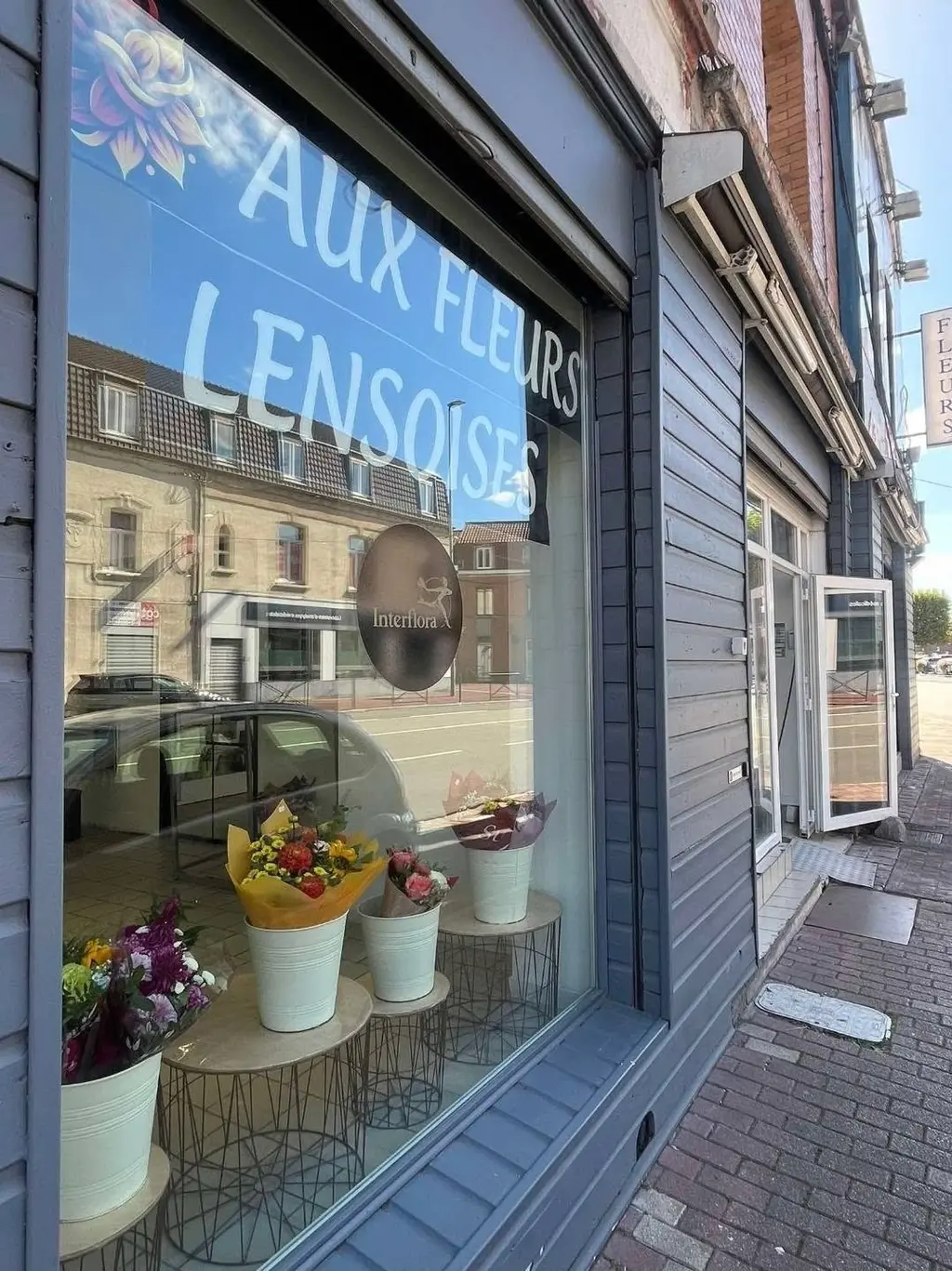 Vitrine de la boutique Aux Fleurs Lensoises, rue René Lanoy à Lens, avec ses seaux de bouquets
