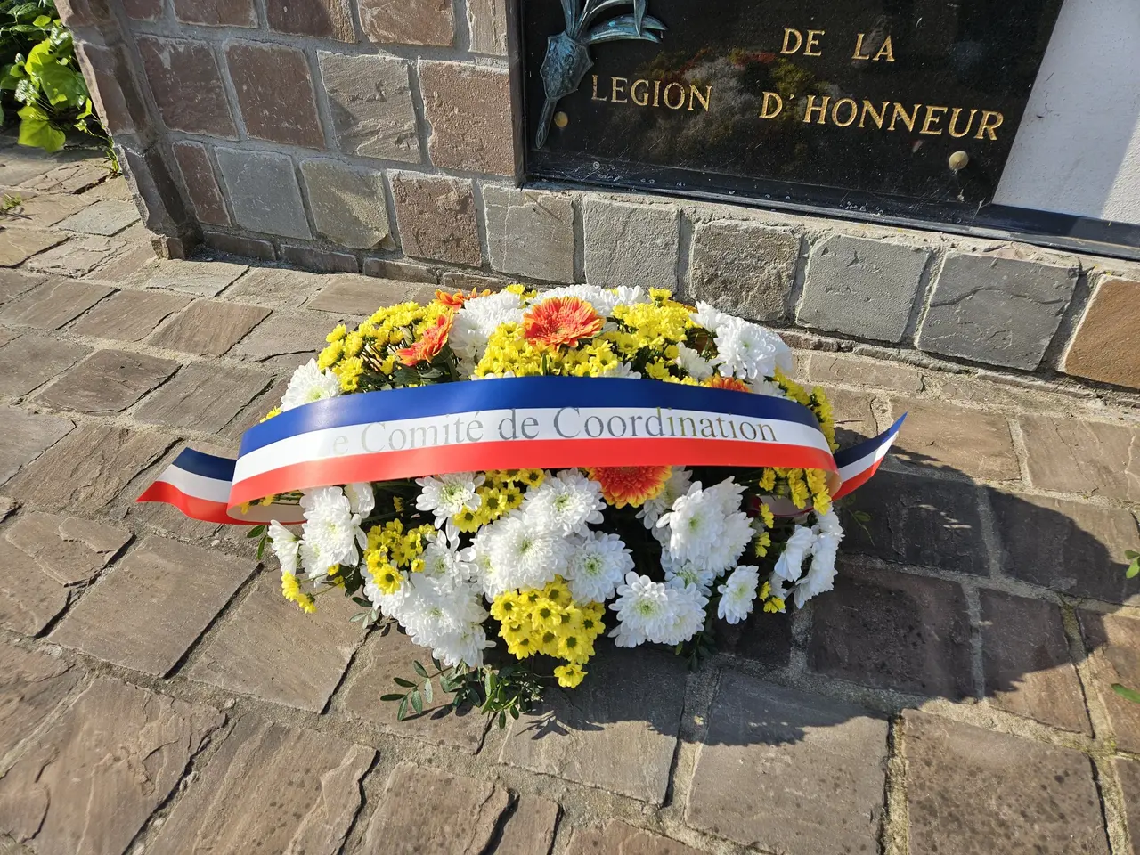 Gerbe tricolore déposée au pied d'un monument commémoratif