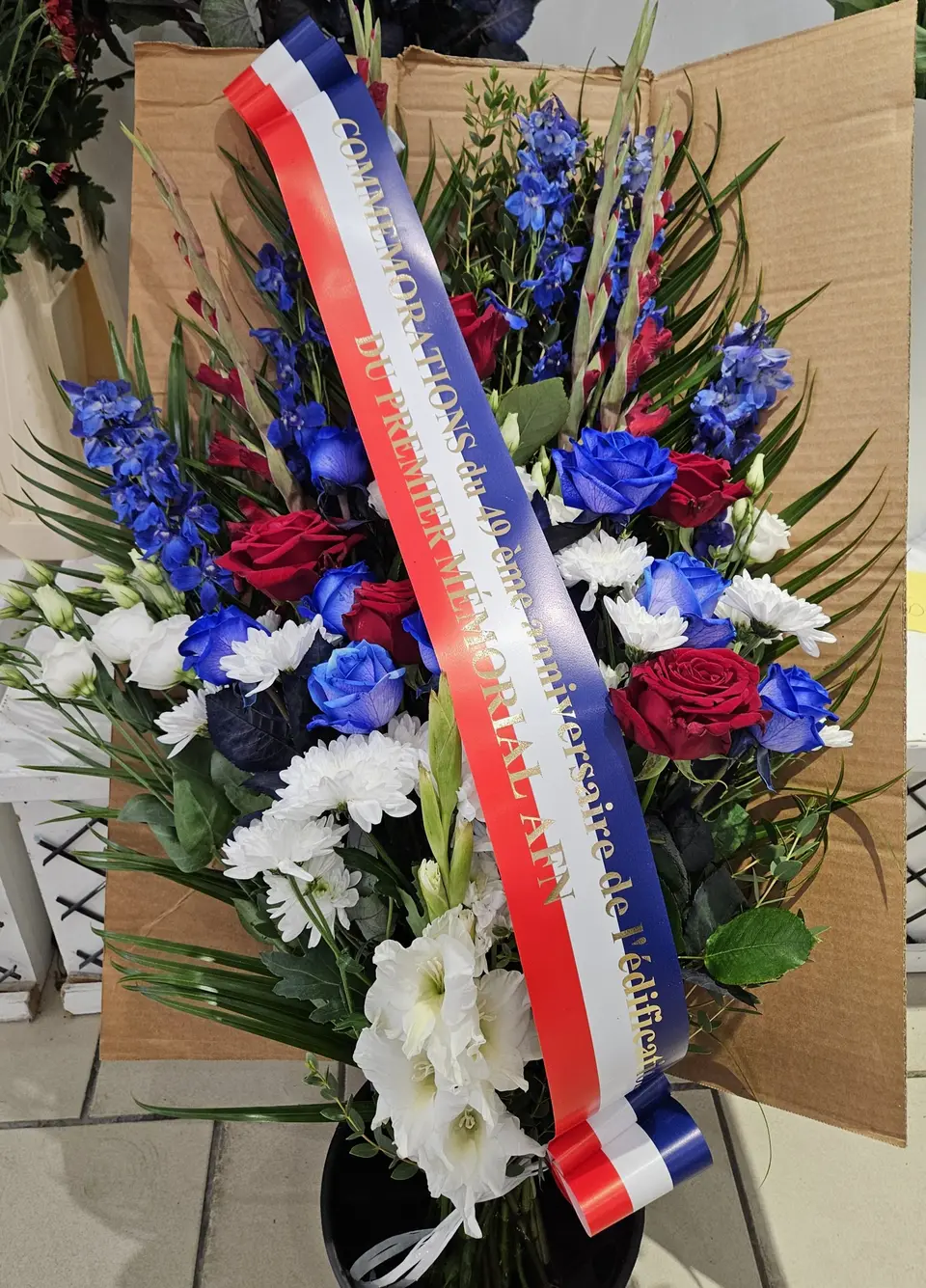 Gerbe tricolore avec delphinium bleu et roses rouges