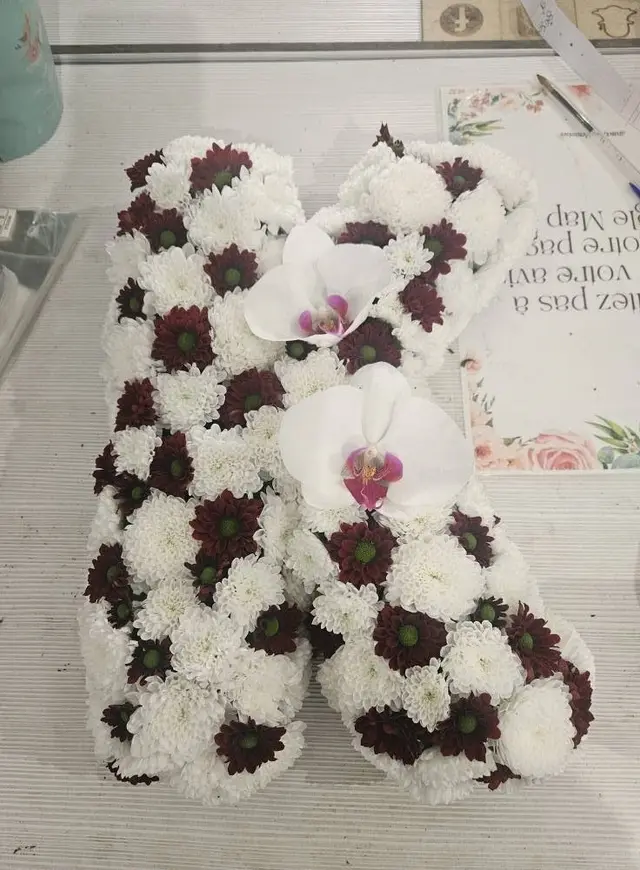 Lettre fleurie en chrysanthèmes blancs et bordeaux, ornée de deux orchidées