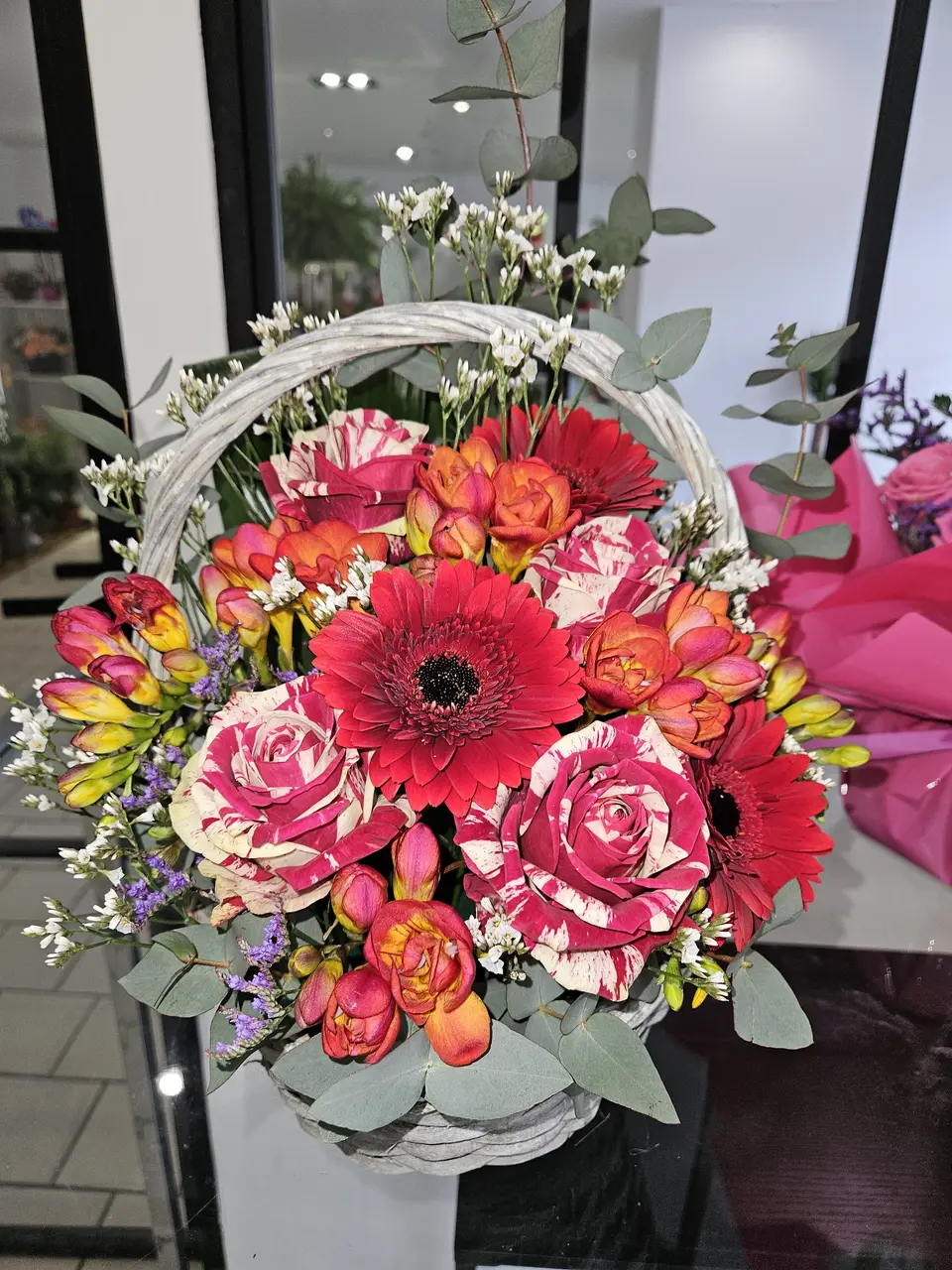 Panier fleuri rouge et orange avec roses et gerberas